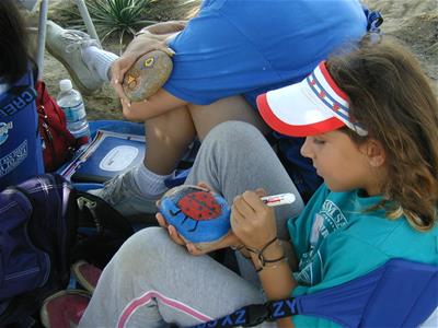 Girl Paints Ladybug on Rock